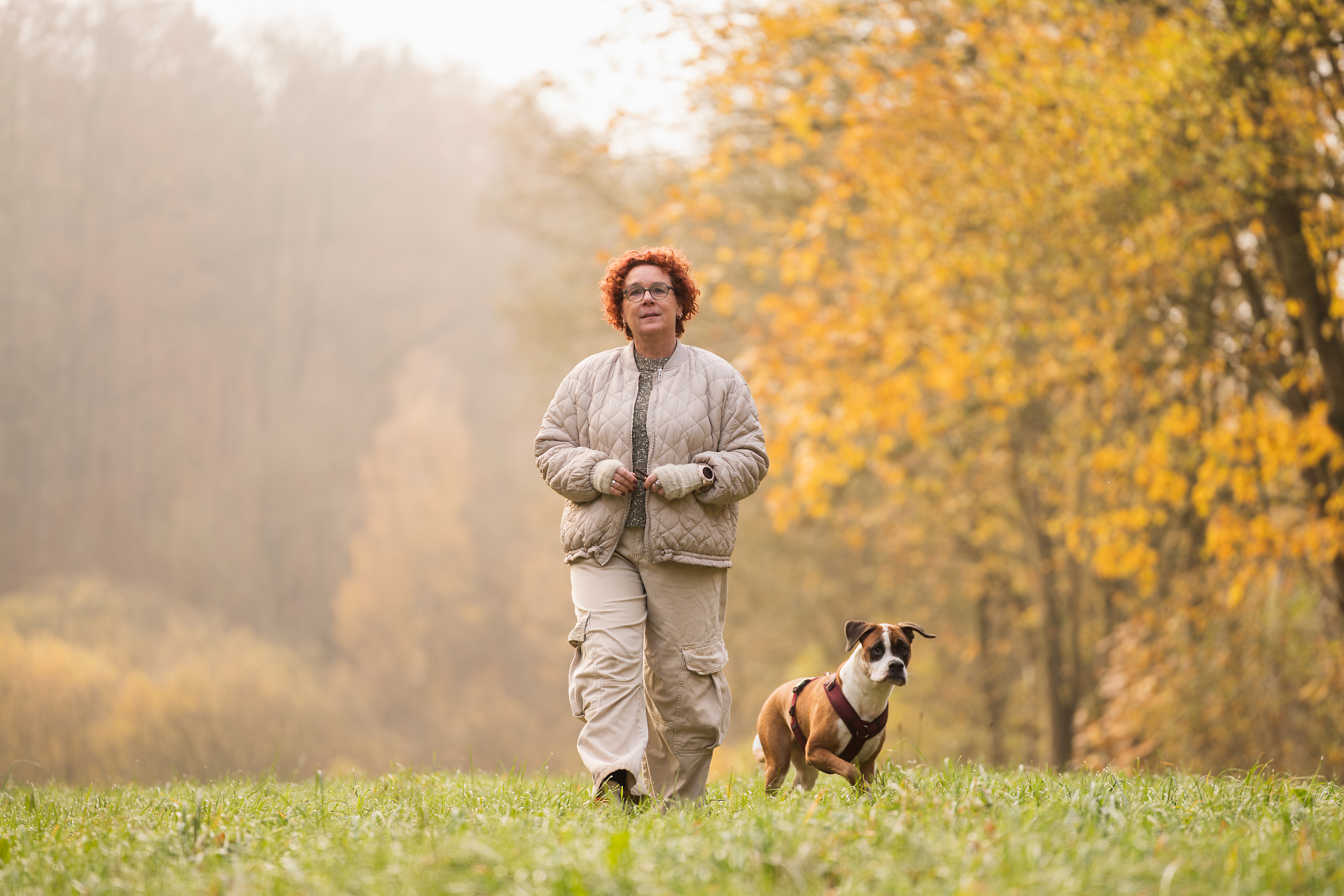 Birgit Frieda Meyer geht mit ihrem Hund über eine herbstliche Wiese